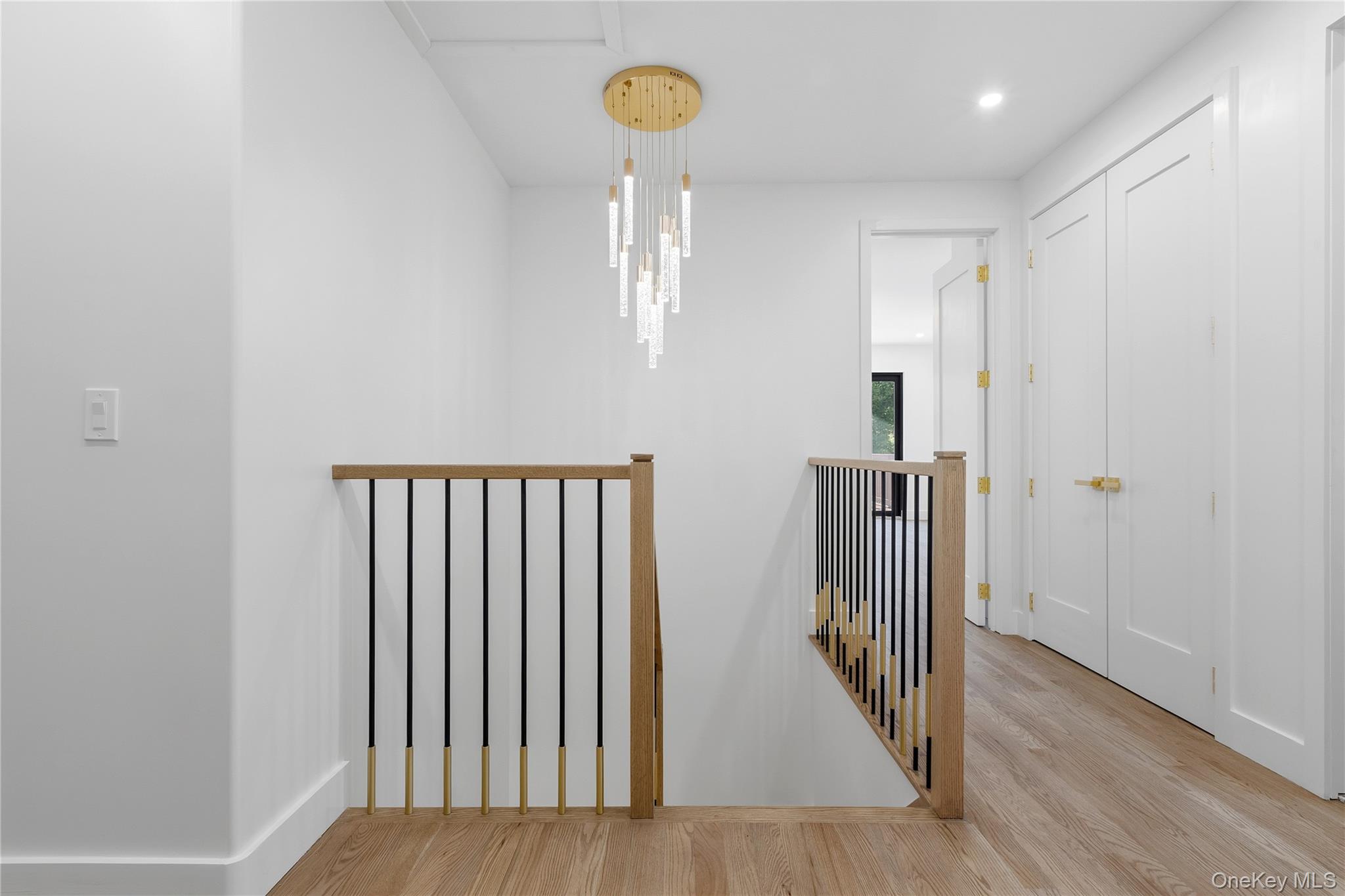 548 Lakes Road Monroe, NY 10950 - Photo 29 of 50 a view of a hallway with wooden floor and a chandelier