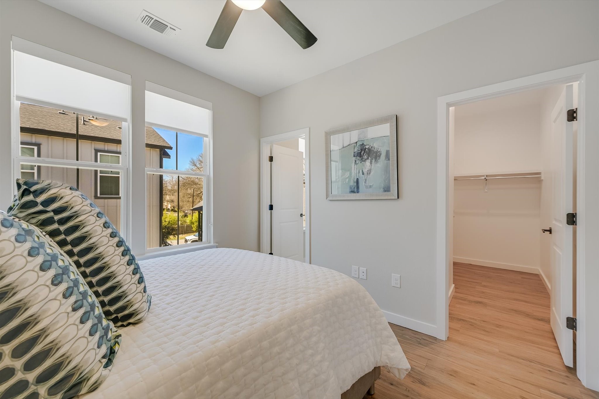 3809 Valley View Road, Unit 7 Austin, TX 78704 - Photo 15 of 21 Bedroom featuring ceiling fan, a walk in closet, and light wood-type flooring