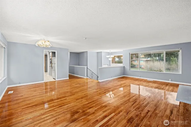 a view of empty room with wooden floor and window