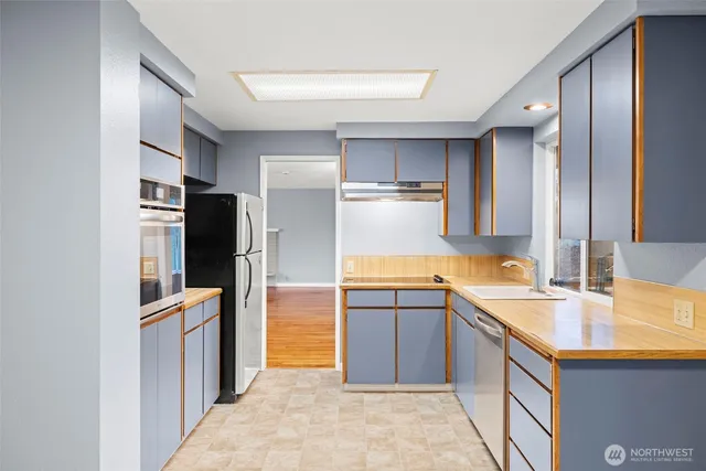 a kitchen with stainless steel appliances granite countertop a refrigerator and a sink