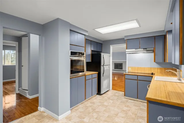 a kitchen with stainless steel appliances granite countertop a refrigerator and a stove top oven