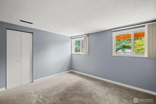 a view of an empty room with a fireplace and window