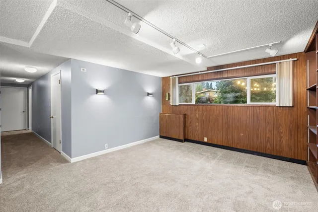 a view of an empty room with a fireplace and a window