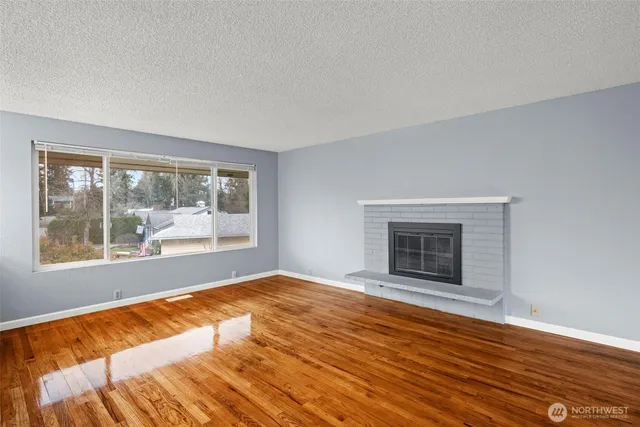 a view of an empty room with a fireplace and a window