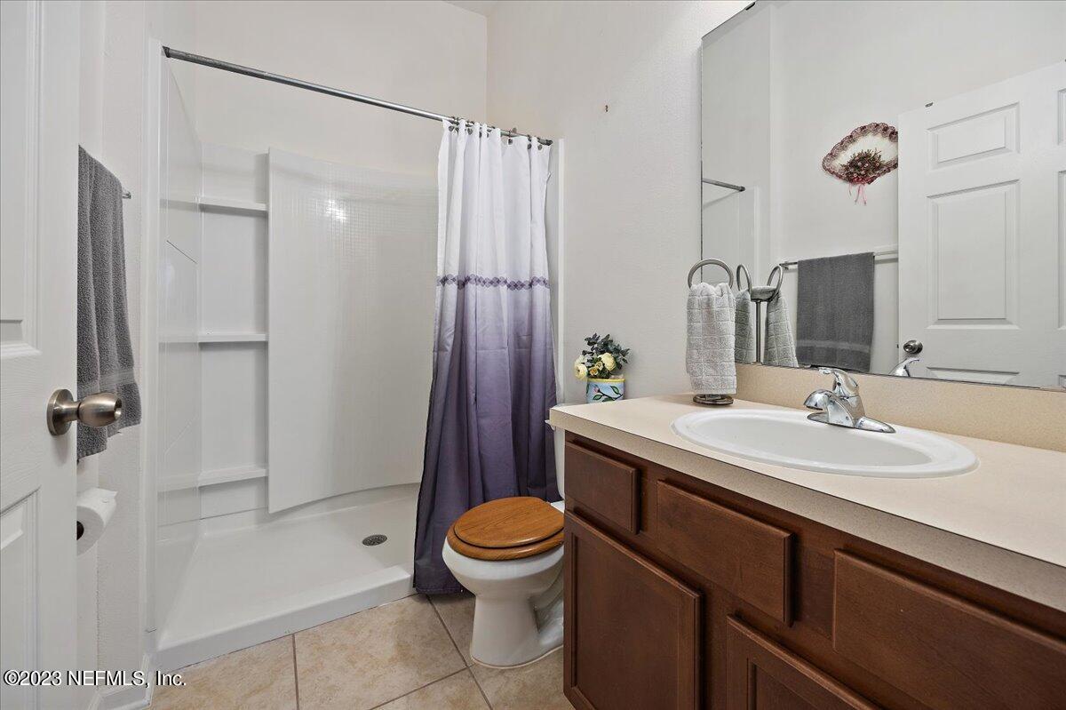 605 Golden Lake Loop St. Augustine, FL 32084 - Photo 12 of 20 a bathroom with a sink a toilet a mirror and shower