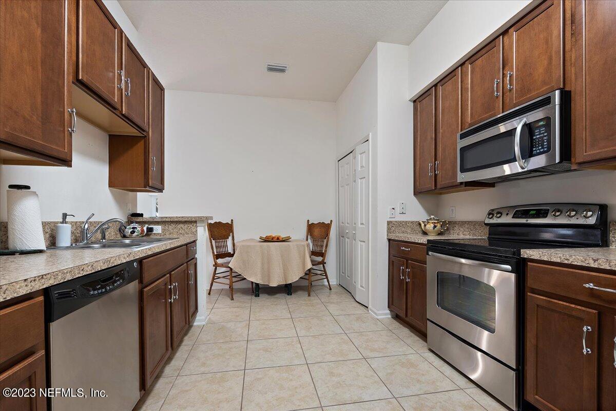 605 Golden Lake Loop St. Augustine, FL 32084 - Photo 8 of 20 a kitchen with stainless steel appliances a stove microwave and cabinets