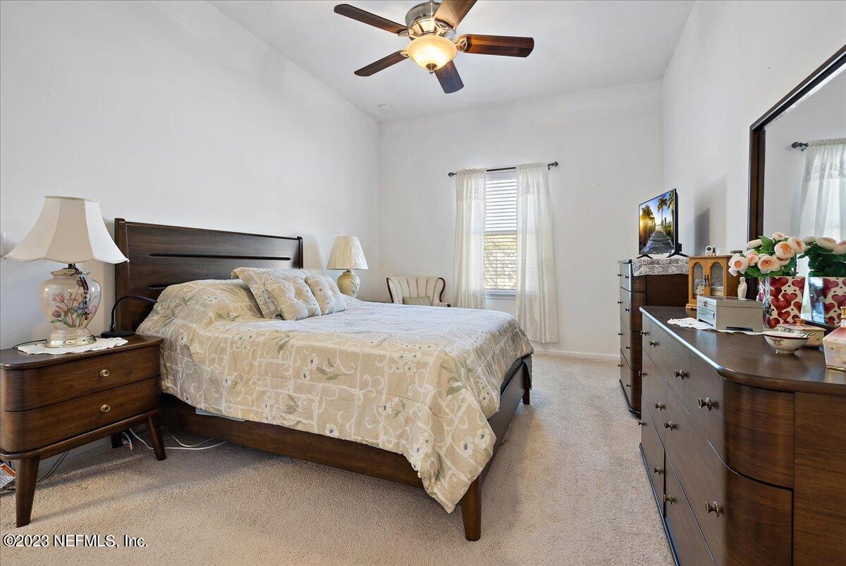 605 Golden Lake Loop St. Augustine, FL 32084 - Photo 10 of 20 a bedroom with a bed and a chandelier