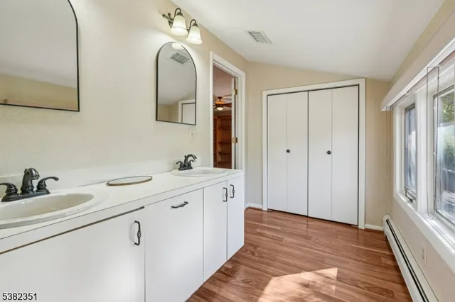 a spacious bathroom with a double vanity sink and mirror