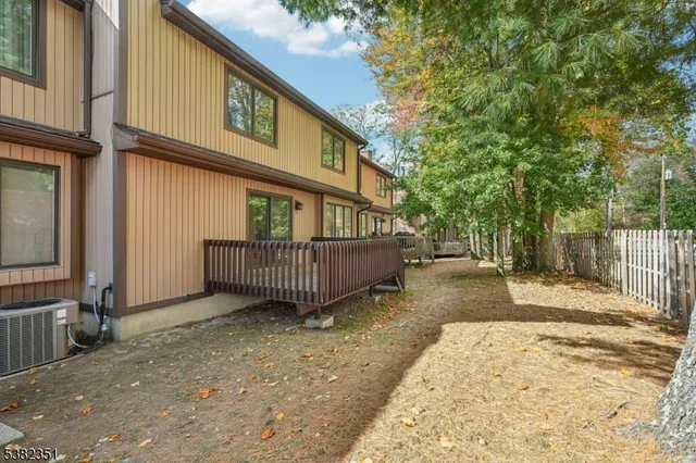 a view of a house with a yard and wooden fence