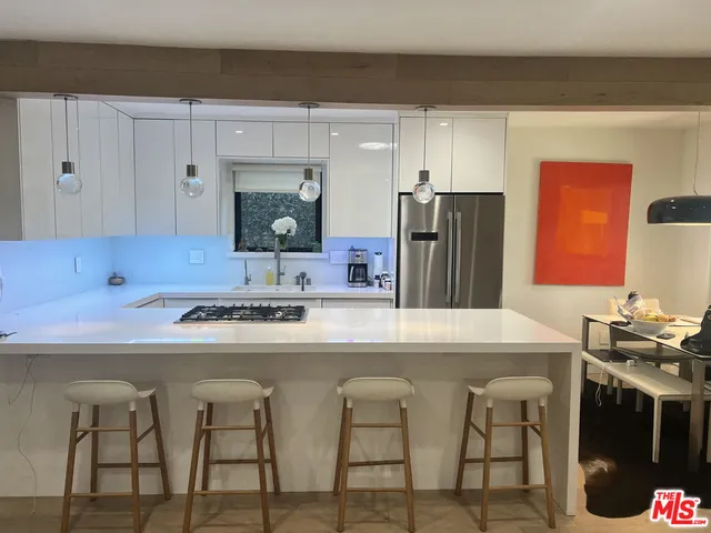 a kitchen with stainless steel appliances a table and chairs