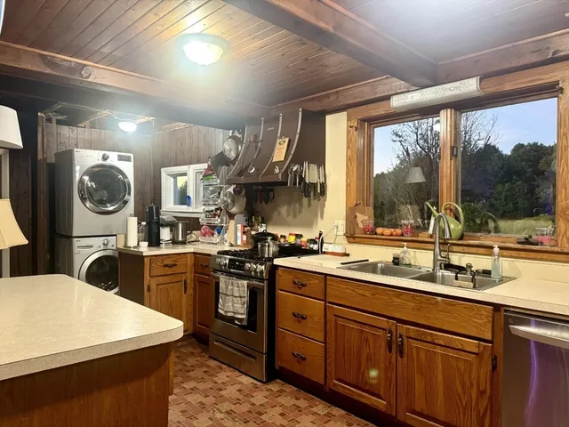 a kitchen with stainless steel appliances granite countertop a refrigerator a stove and a sink