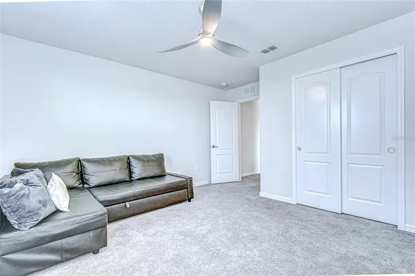 a spacious bedroom with a bed and a flat screen tv