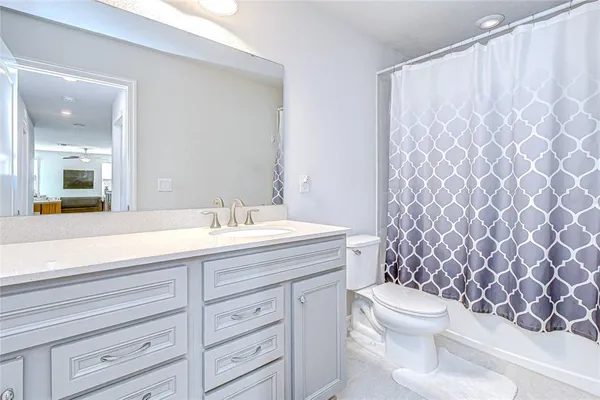 a spacious bedroom with a bed and a ceiling fan