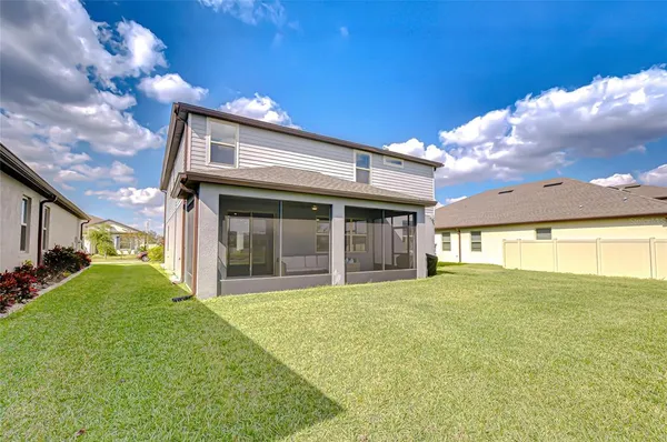 a view of a house with a big yard and large tree