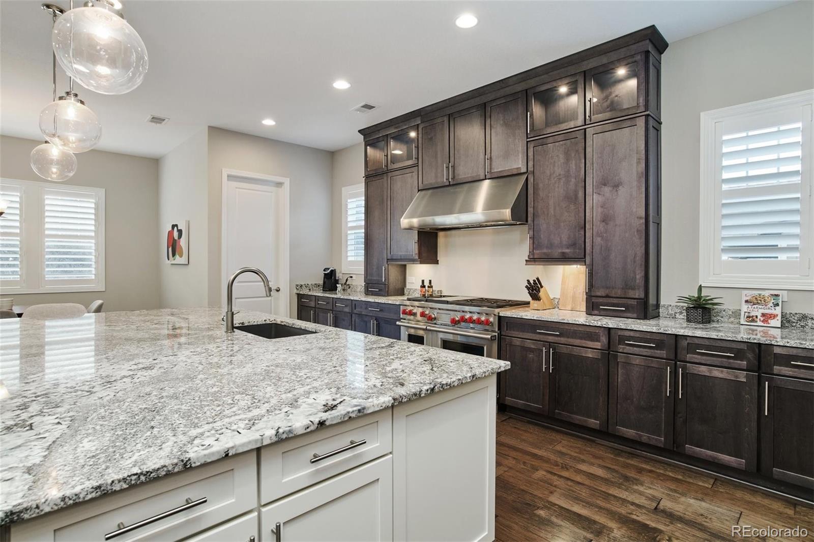 4907 Hogback Ridge Road Morrison, CO 80465 - Photo 11 of 40 a kitchen with stainless steel appliances granite countertop a sink a stove and a wooden cabinets