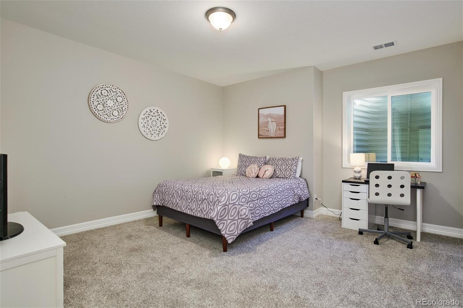 4907 Hogback Ridge Road Morrison, CO 80465 - Photo 29 of 40 a bedroom with a bed and a chair