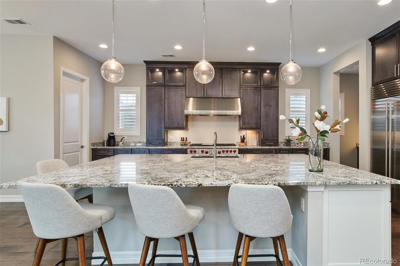 4907 Hogback Ridge Road Morrison, CO 80465 - Photo 9 of 40 a kitchen with granite countertop a table chairs stove and cabinets