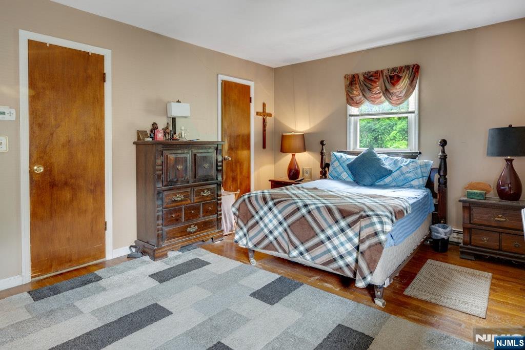 185 Ratzer Road Wayne, NJ 07470 - Photo 29 of 36 a bedroom with a bed and wooden floor