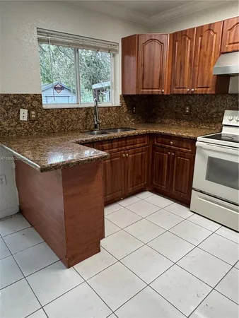 a kitchen with stainless steel appliances granite countertop a sink counter space cabinets and a large window