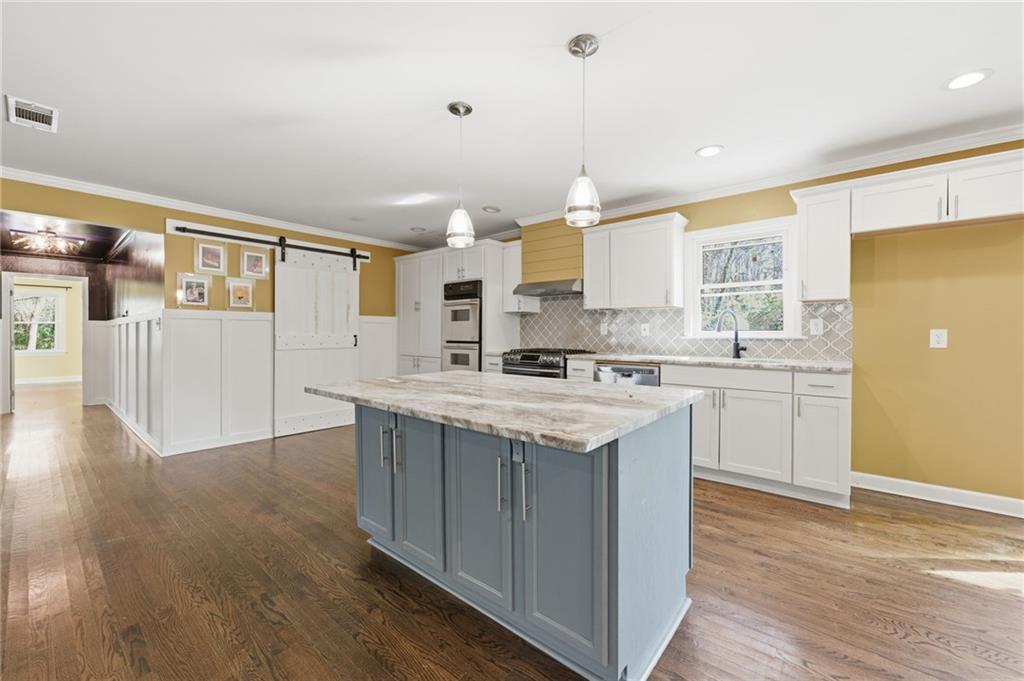 1532 Alverado Way Decatur, GA 30032 - Photo 12 of 41 a kitchen with stainless steel appliances granite countertop a sink a stove a refrigerator and island with wooden floor