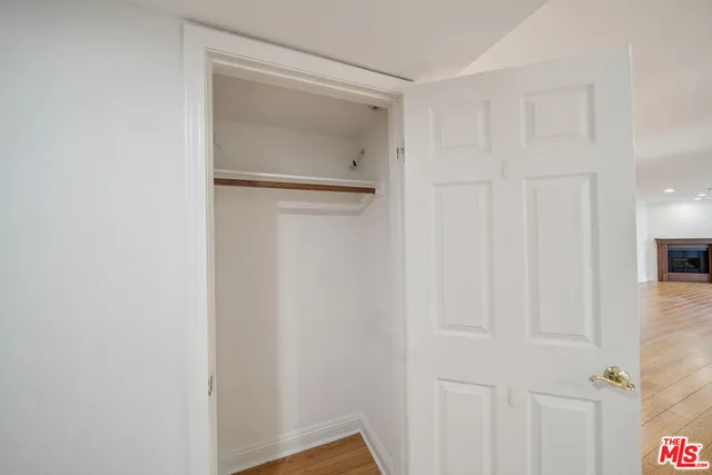 a view of a hallway with wooden shelves