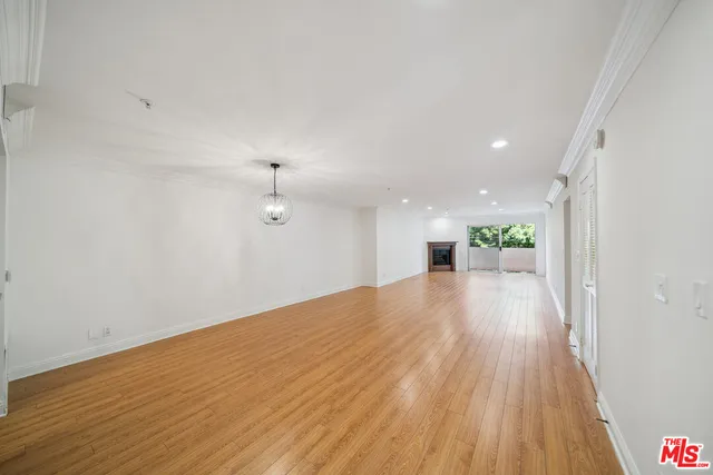 a view of a big room with wooden floor and windows