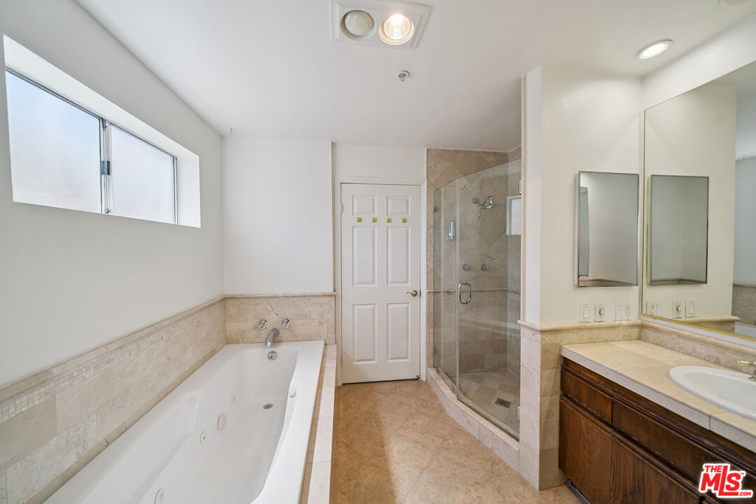 1508 Greenfield Avenue, Unit 206 Los Angeles, CA 90025 - Photo 26 of 31 a bathroom with a tub sink and mirror