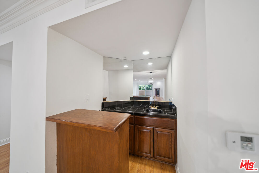 1508 Greenfield Avenue, Unit 206 Los Angeles, CA 90025 - Photo 6 of 31 a kitchen with granite countertop a sink and a stove top oven