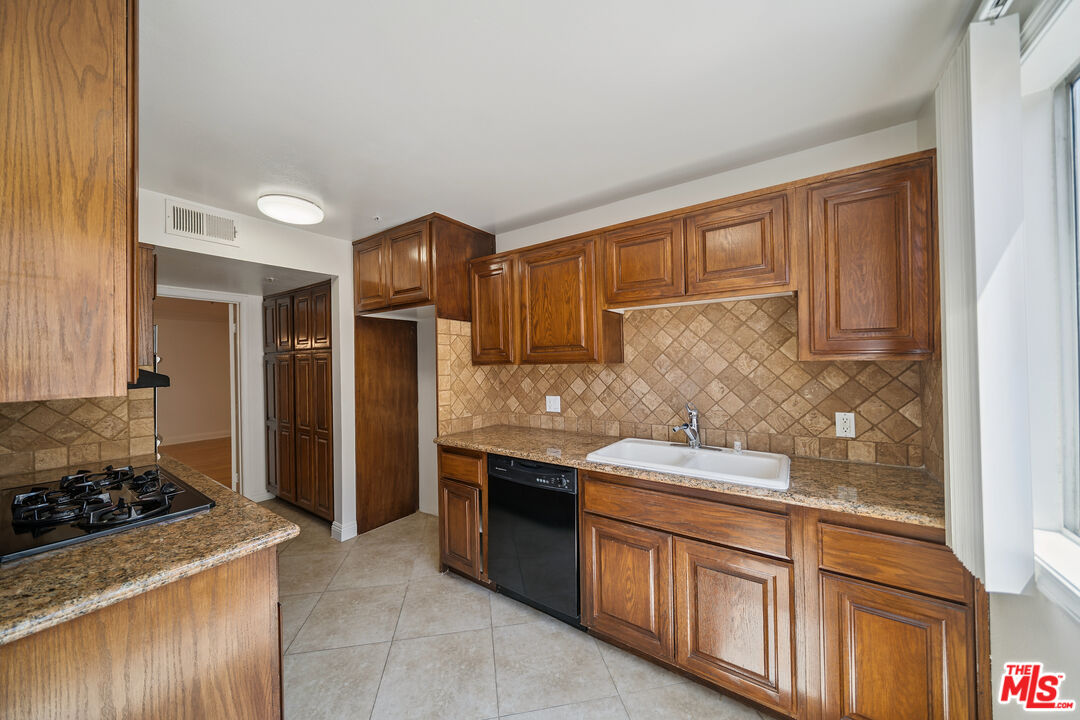 1508 Greenfield Avenue, Unit 206 Los Angeles, CA 90025 - Photo 10 of 31 a kitchen with stainless steel appliances granite countertop a stove and a refrigerator