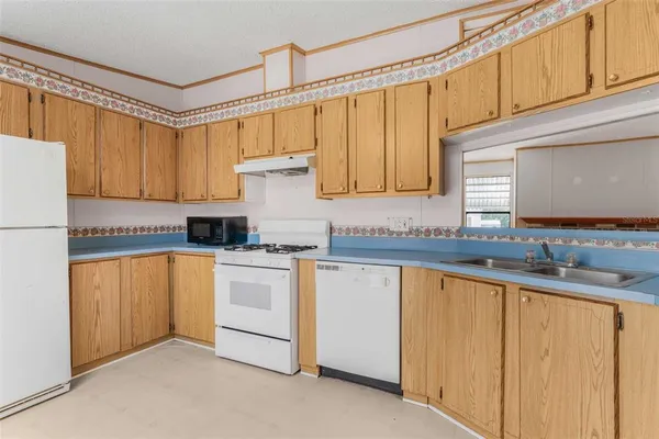 a kitchen with stainless steel appliances granite countertop a sink and a refrigerator