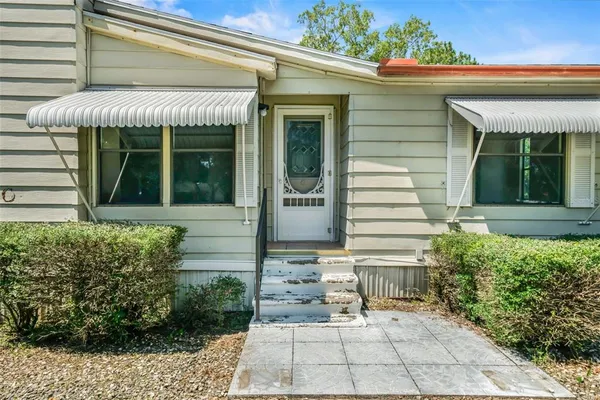 a aerial view of a house with yard and tree s