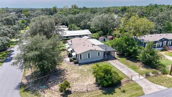 an aerial view of a house with a yard and trees