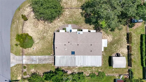 an aerial view of residential houses with outdoor space and trees
