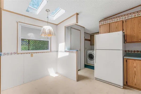 a view of a hallway with a refrigerator and a window