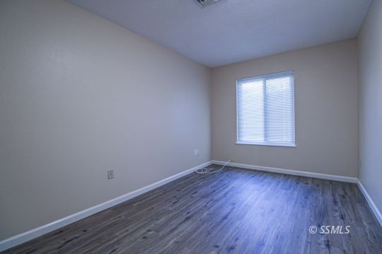 516 Randall Street Ridgecrest, CA 93555 - Photo 29 of 50 an empty room with wooden floor and windows