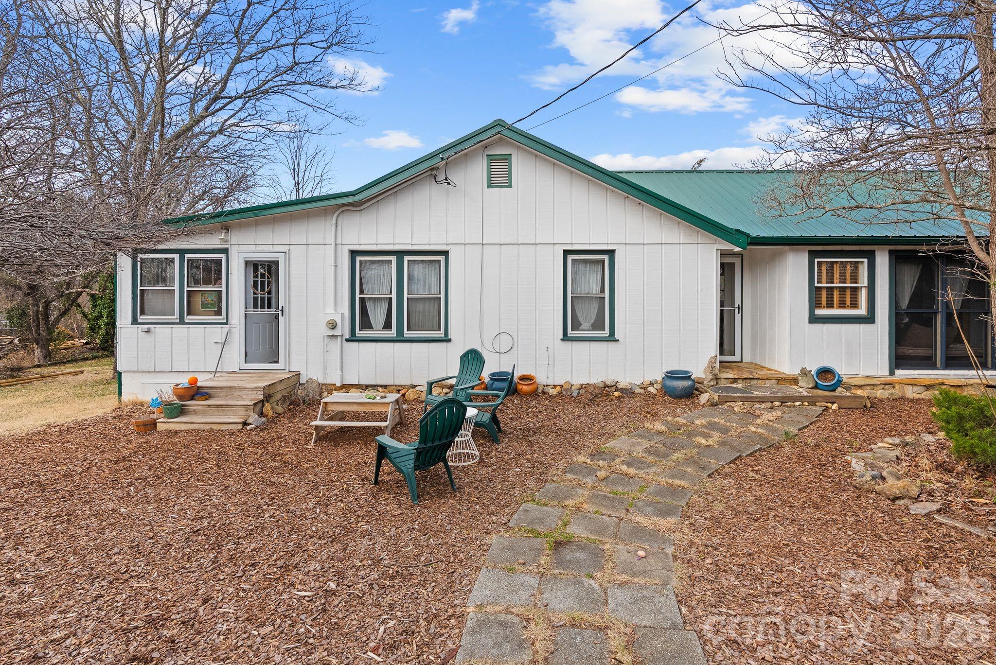 a backyard of a house with table and chairs