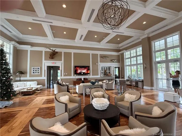 a large living room with stainless steel appliances kitchen island granite countertop furniture and a flat screen tv