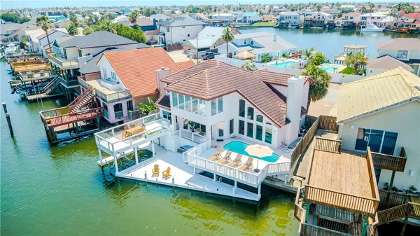 an aerial view of a house with swimming pool lawn chairs and a yard