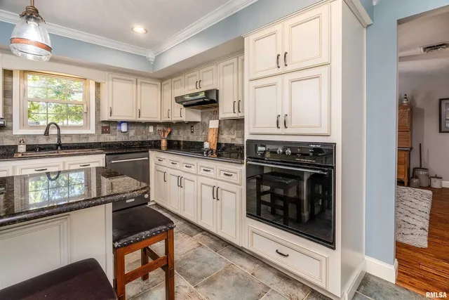 a kitchen with stainless steel appliances granite countertop a stove a sink and a microwave