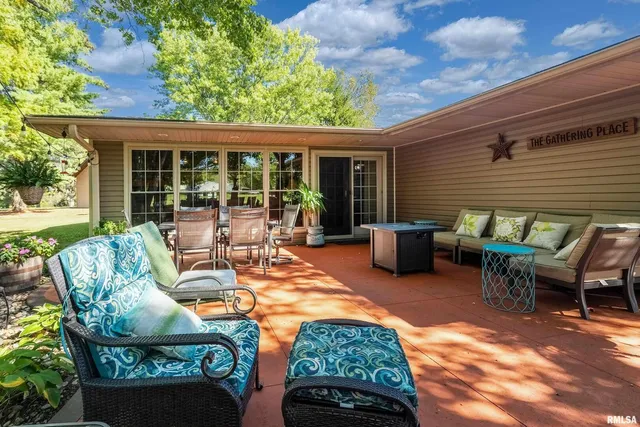 a view of a patio with table and chairs with wooden fence