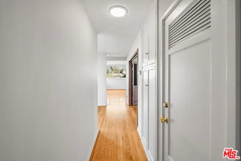a view of a hallway with wooden floor