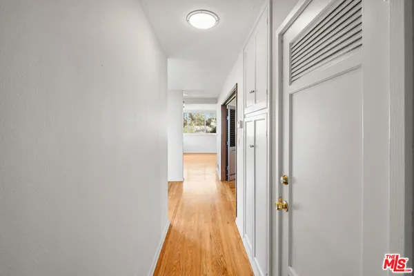a view of a hallway with wooden floor