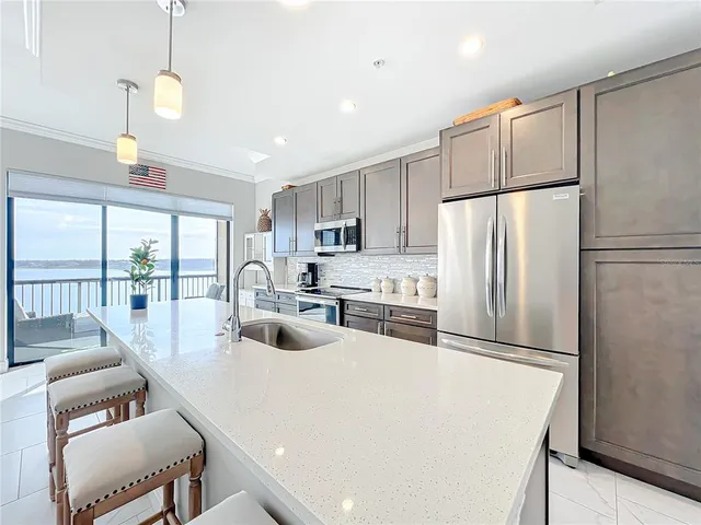 a kitchen with granite countertop a sink stainless steel appliances and cabinets