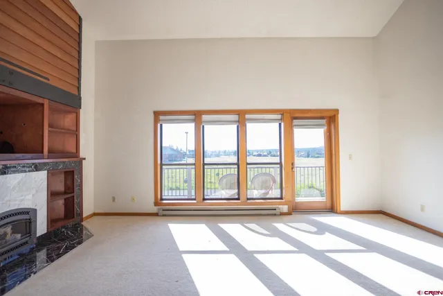 a view of an empty room with a fireplace and a window