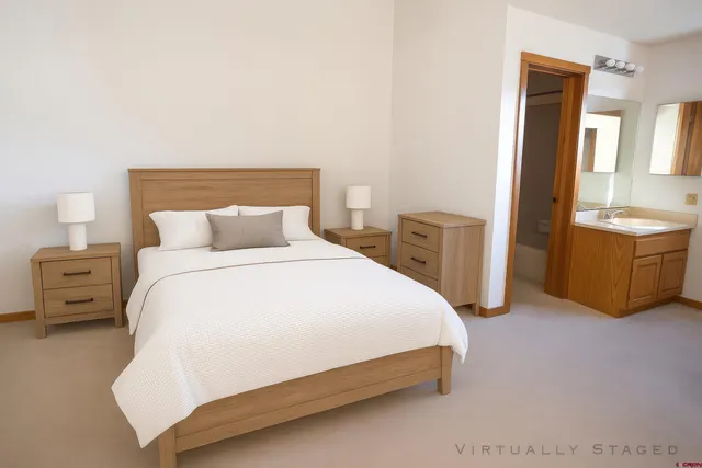 a bedroom with a bed and dresser with mirror