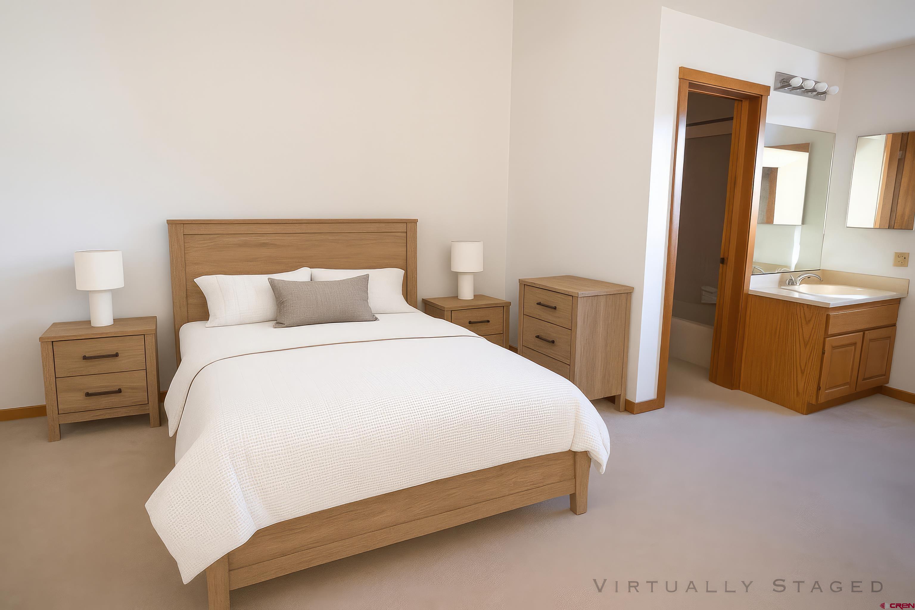 164 Valley View Drive, Unit 3218 Pagosa Springs, CO 81147 - Photo 22 of 39 a bedroom with a bed and dresser with mirror