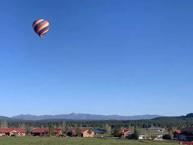 an aerial view of residential house with green space and mountain view