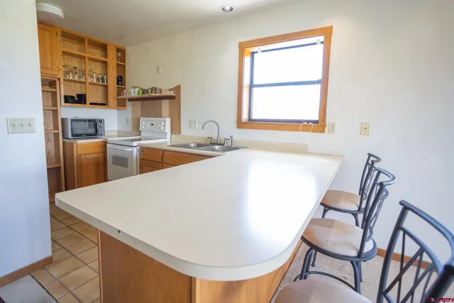 a living room with stainless steel appliances furniture a computer and a window