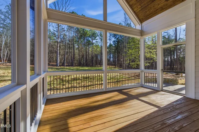 an empty room with windows and ceiling fan