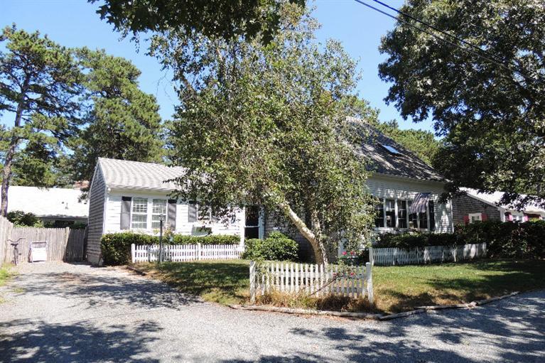 23 Shore Rd Extension West Harwich, MA 02671 - Photo 1 of 24 a front view of a house with a garden and trees